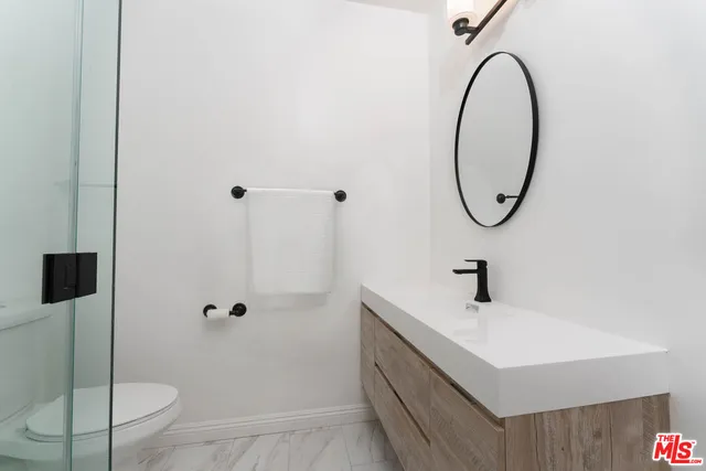a bathroom with a sink a toilet and shower