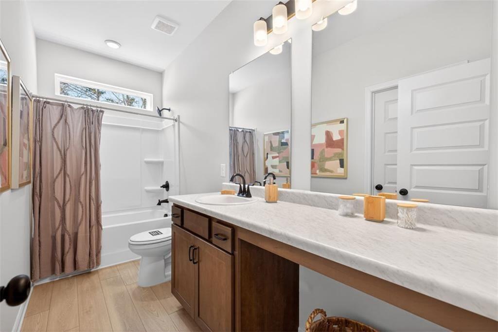 253 Shire Loop Calhoun, GA 30701 - Photo 28 of 38 a bathroom with a double vanity sink toilet mirror and shower