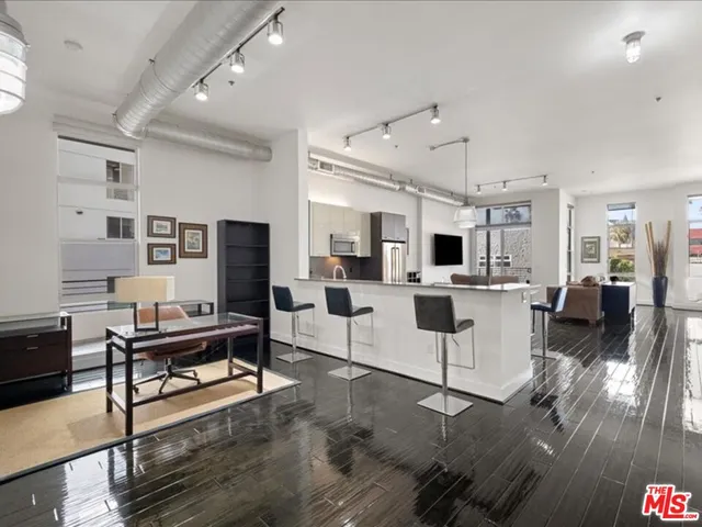 a kitchen with stainless steel appliances kitchen island granite countertop a stove a sink a dining table and chairs