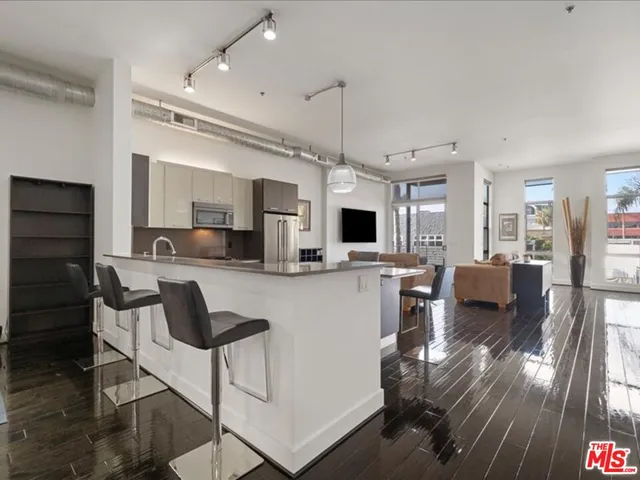 a kitchen with kitchen island a counter top space a sink stainless steel appliances and cabinets