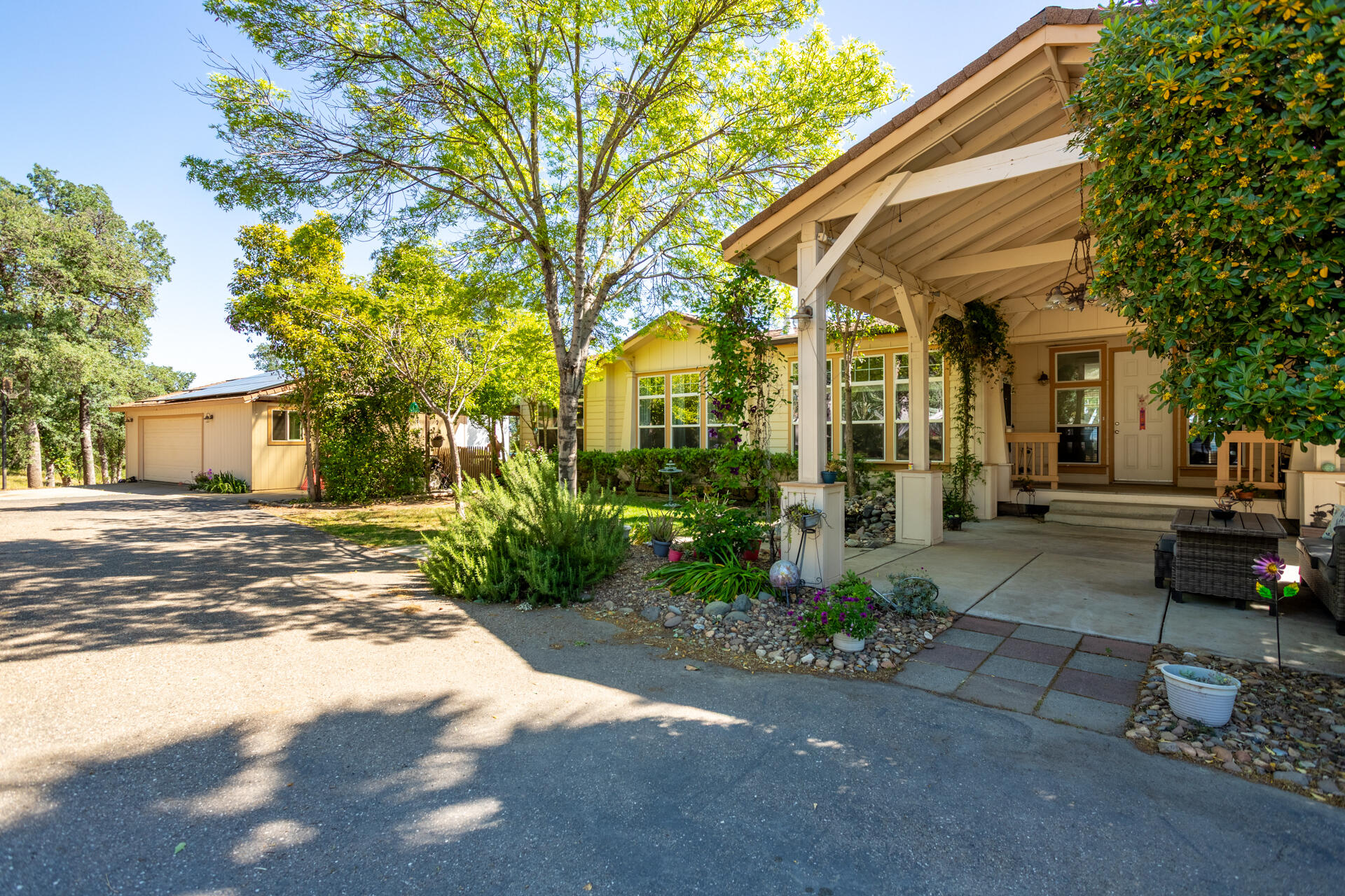 21100 Doe Run Way Red Bluff, CA 96080 - Photo 35 of 93 a view of a white house next to a yard and a large tree