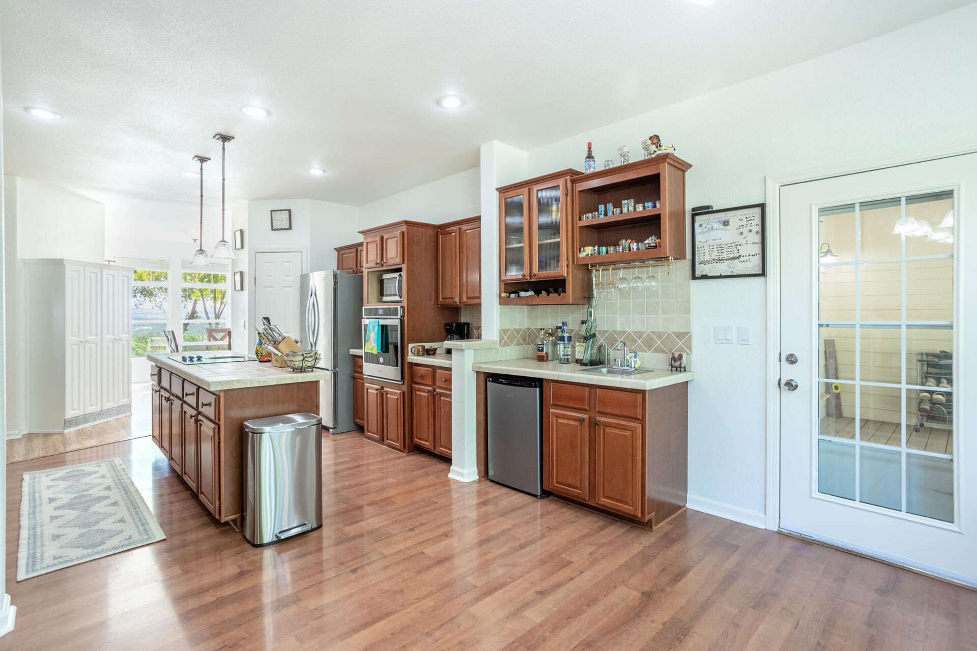 21100 Doe Run Way Red Bluff, CA 96080 - Photo 5 of 93 a kitchen with stainless steel appliances granite countertop a refrigerator a sink dishwasher a oven and a dining table with wooden floor