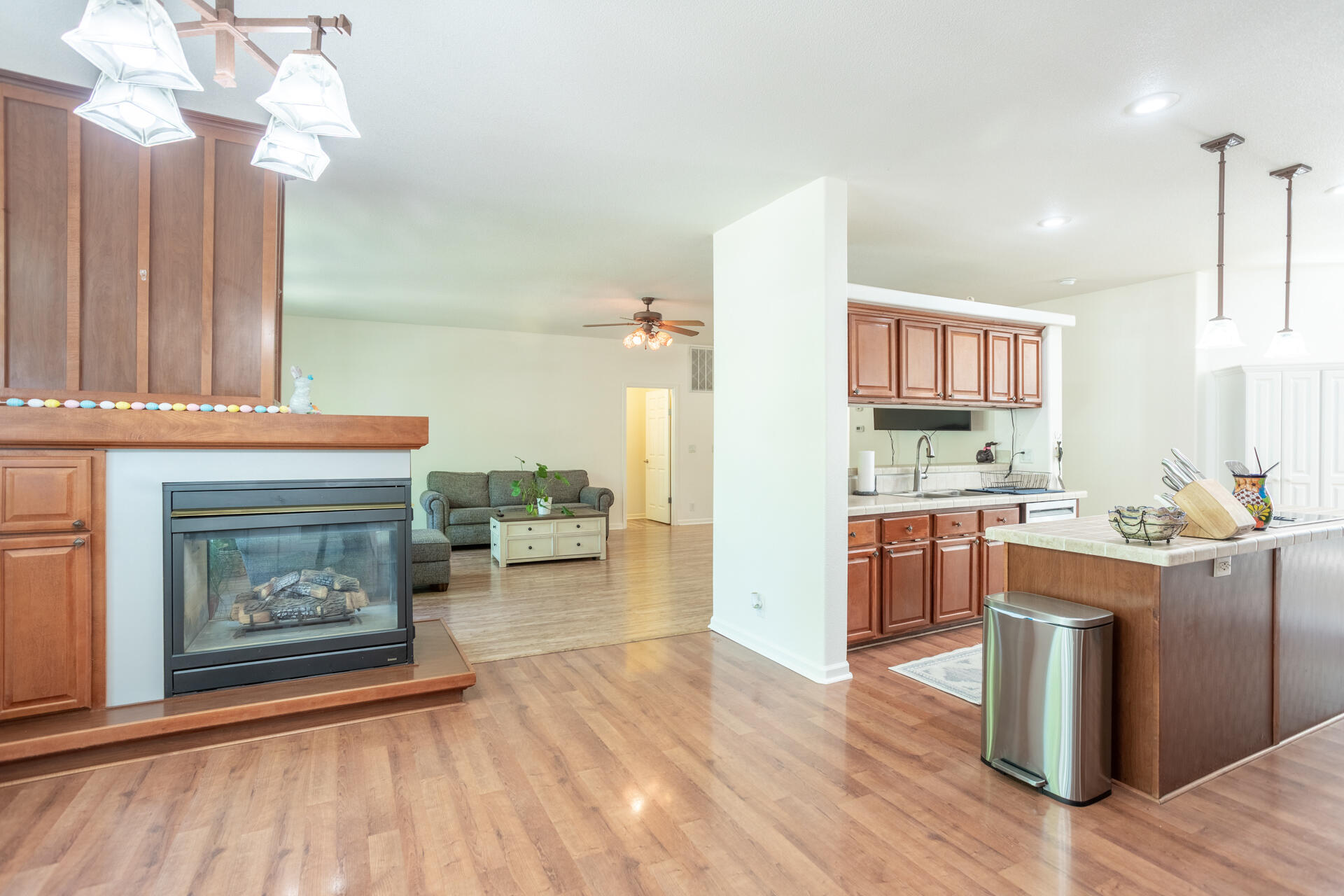 21100 Doe Run Way Red Bluff, CA 96080 - Photo 6 of 93 a open kitchen with granite countertop a stove top oven a sink dishwasher and a fireplace with wooden floor