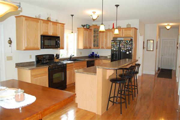 49 Old Gilbertville Road Ware, MA 01082 - Photo 3 of 25 a kitchen with stainless steel appliances kitchen island granite countertop a stove a sink a refrigerator a dining table and chairs with wooden floor