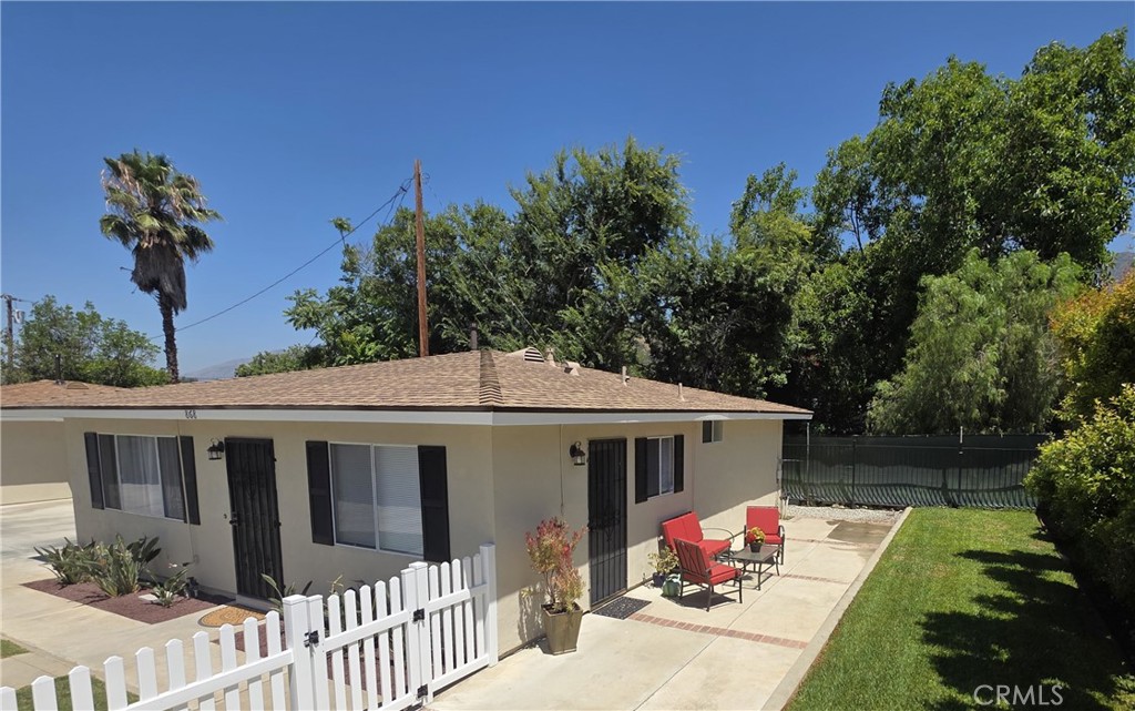 a front view of house with yard and trees in the background