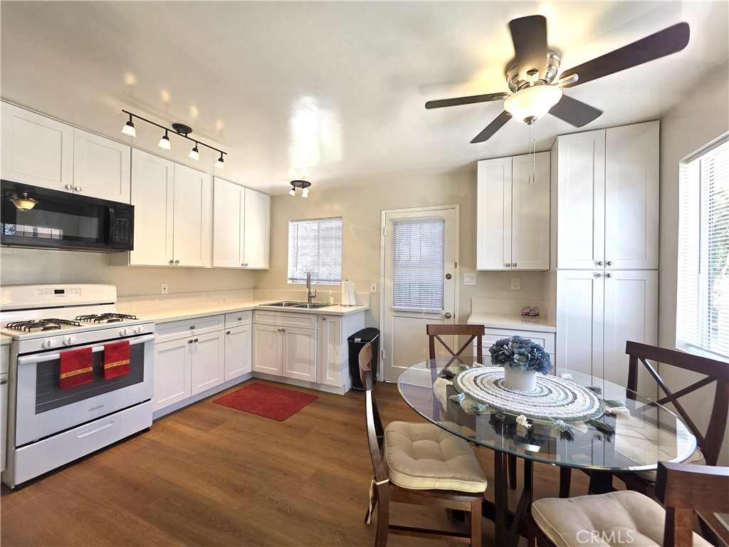 868 Random Lane Duarte, CA 91010 - Photo 5 of 22 a kitchen with a stove a sink dishwasher a dining table and chairs with wooden floor
