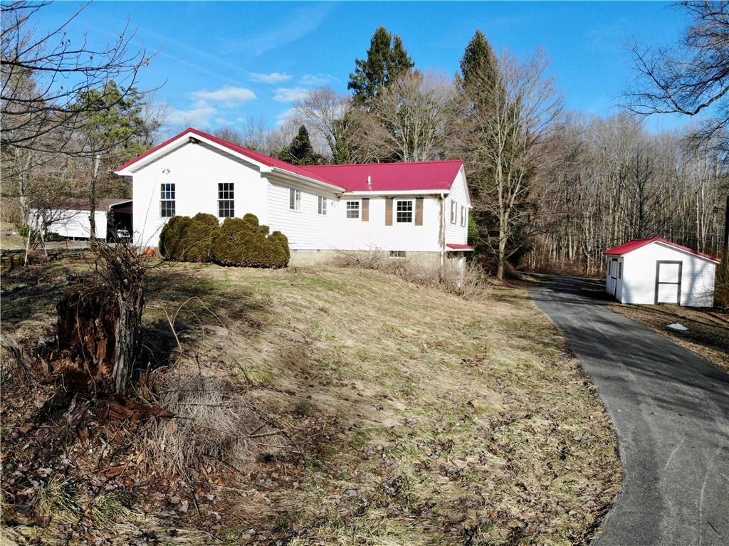 97 Dean Road Sandy Lake, PA 16145 - Photo 22 of 25 a view of a white house with a yard and large tree