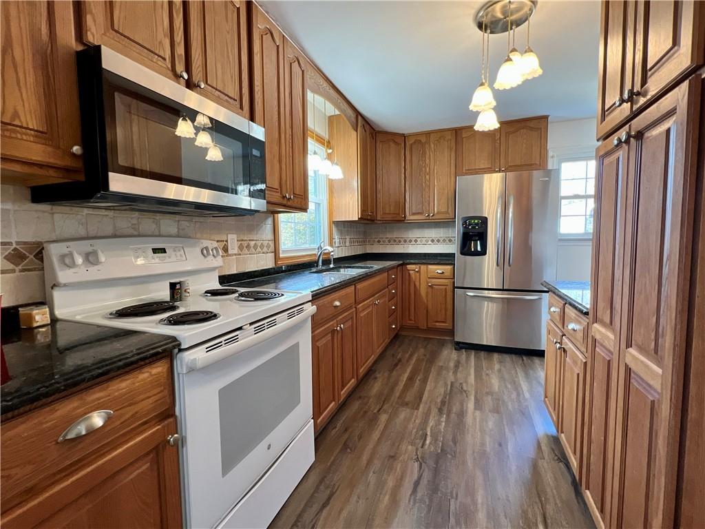 97 Dean Road Sandy Lake, PA 16145 - Photo 7 of 25 a kitchen with stainless steel appliances a sink cabinets and a wooden floor