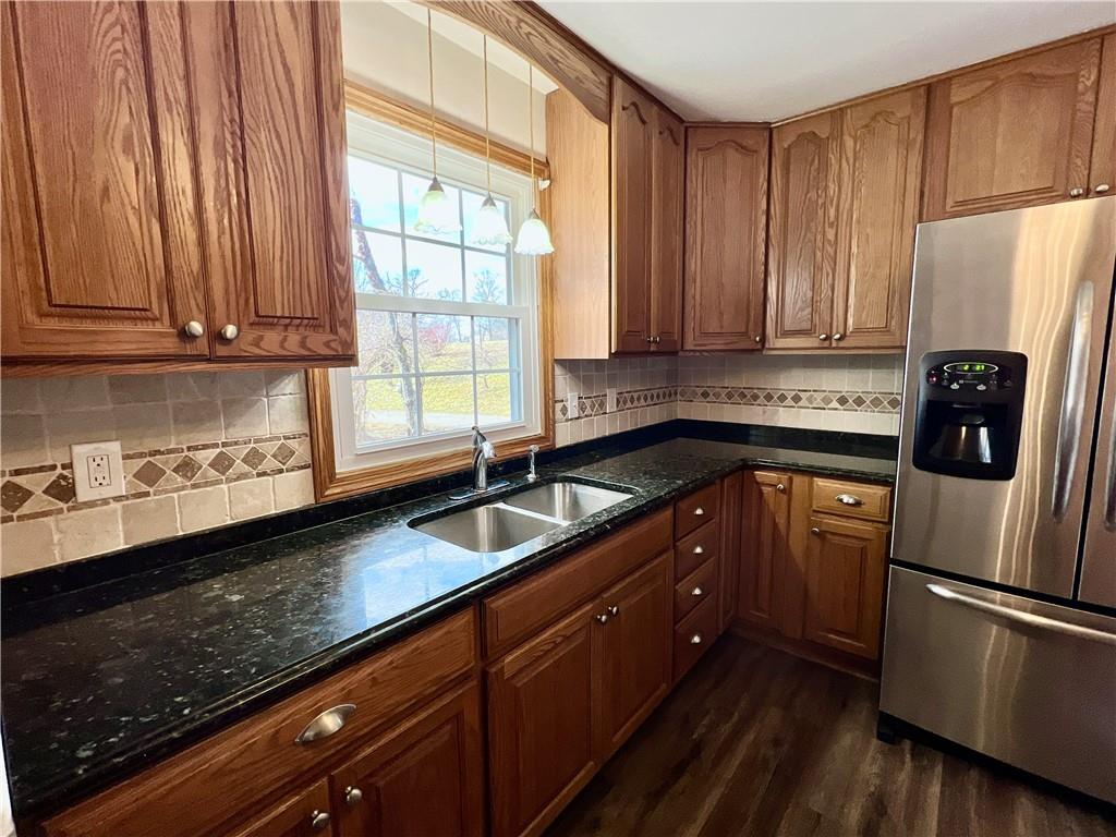 97 Dean Road Sandy Lake, PA 16145 - Photo 8 of 25 a kitchen with granite countertop a refrigerator a sink dishwasher a stove and white cabinets