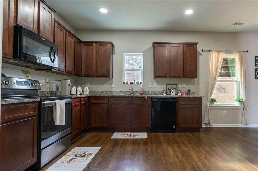 735 Walnut Creek Circle Pendergrass, GA 30567 - Photo 6 of 29 a kitchen with granite countertop a stove a sink and a microwave
