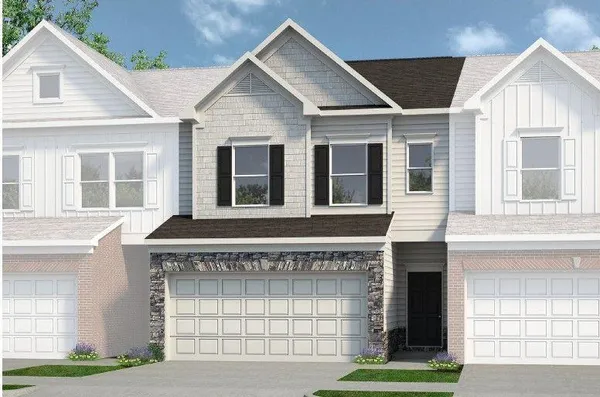 a front view of a house with a garden and garage