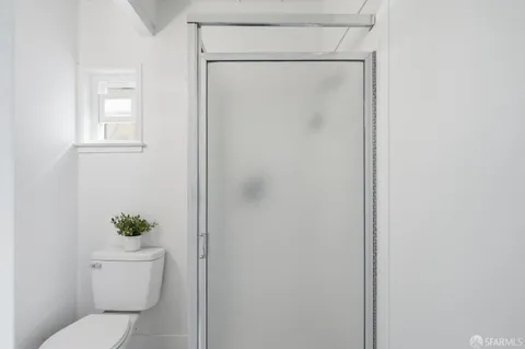 a white toilet sitting next to a shower