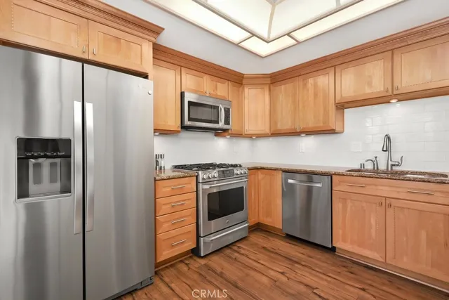 a kitchen with stainless steel appliances granite countertop a refrigerator sink and microwave
