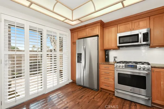 a kitchen with stainless steel appliances a stove a microwave and a window