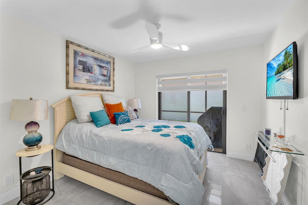 820 Southwest 87th Terrace Plantation, FL 33324 - Photo 11 of 41 a bedroom with a bed and a flat screen tv