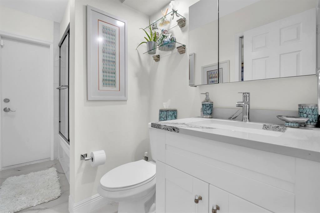 820 Southwest 87th Terrace Plantation, FL 33324 - Photo 12 of 41 a bathroom with a granite countertop sink a toilet and mirror
