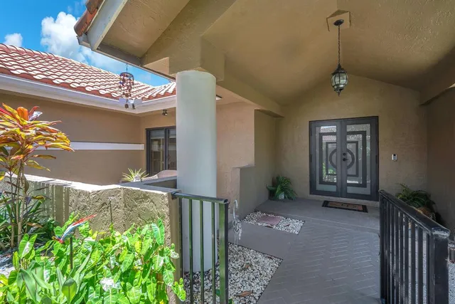 a view of a house with a yard and potted plants