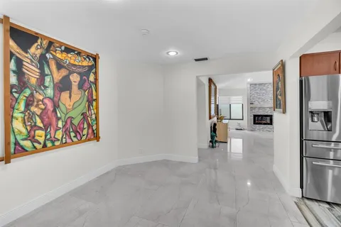 a view of hallway with cabinets and refrigerator