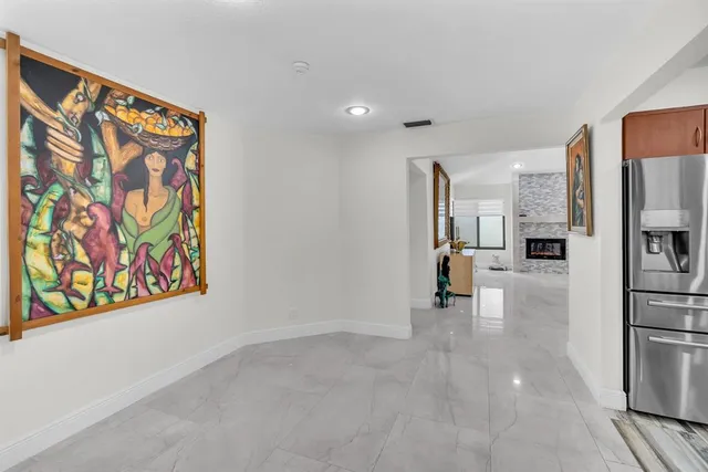 a view of hallway with cabinets and refrigerator