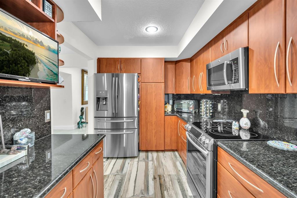 820 Southwest 87th Terrace Plantation, FL 33324 - Photo 4 of 41 a kitchen with granite countertop stainless steel appliances a refrigerator a stove a sink and cabinets