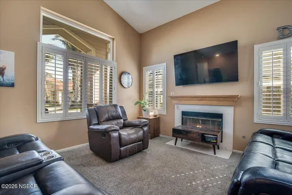 a living room with furniture a flat screen tv and a fireplace