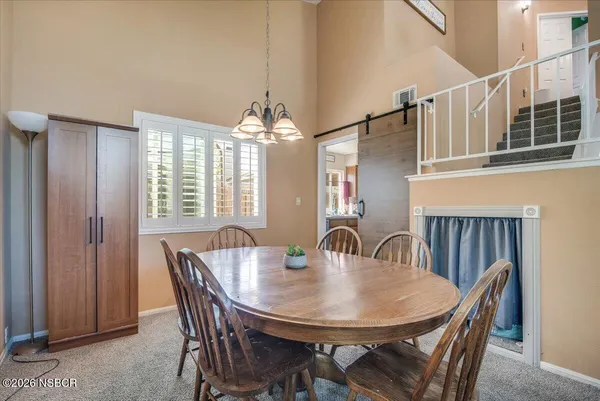 a view of a dining room with furniture and chandelier