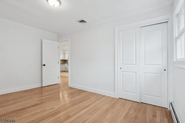 a view of an empty room with wooden floor