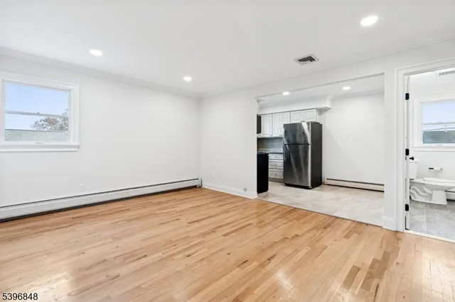 a view of an empty room with wooden floor