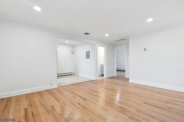 a view of an empty room with wooden floor