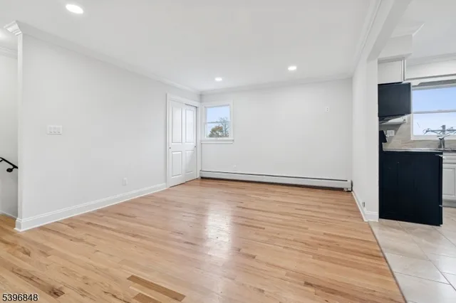 a view of an empty room with wooden floor