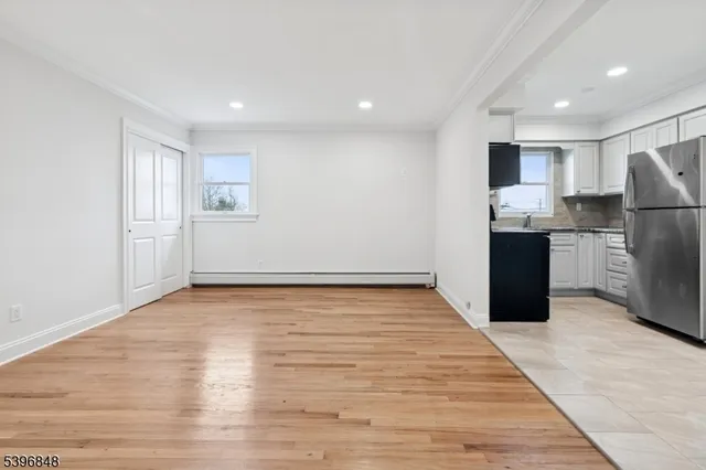 a view of kitchen with refrigerator and wooden floor