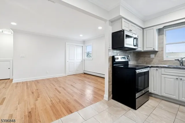 a kitchen with granite countertop a refrigerator and a stove top oven