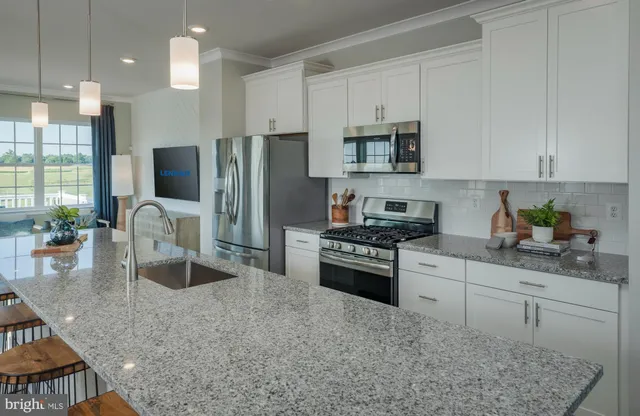 a kitchen with stainless steel appliances granite countertop a stove refrigerator sink and cabinets