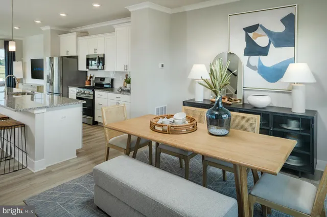 a kitchen with a dining table chairs and refrigerator