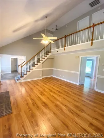 a view of staircase and living room with wooden floor