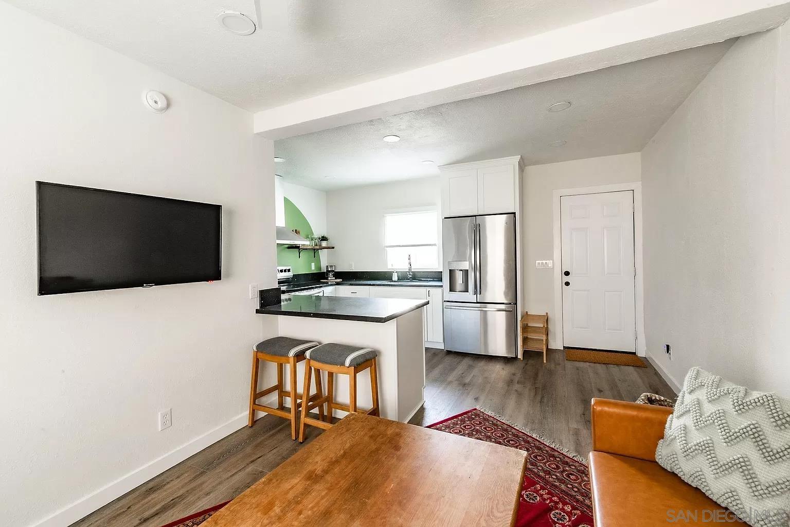 2948 Franklin Avenue San Diego, CA 92113 - Photo 28 of 47 a living room with stainless steel appliances wooden floor and a flat screen tv