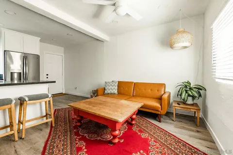 a living room with a bed and a flat screen tv