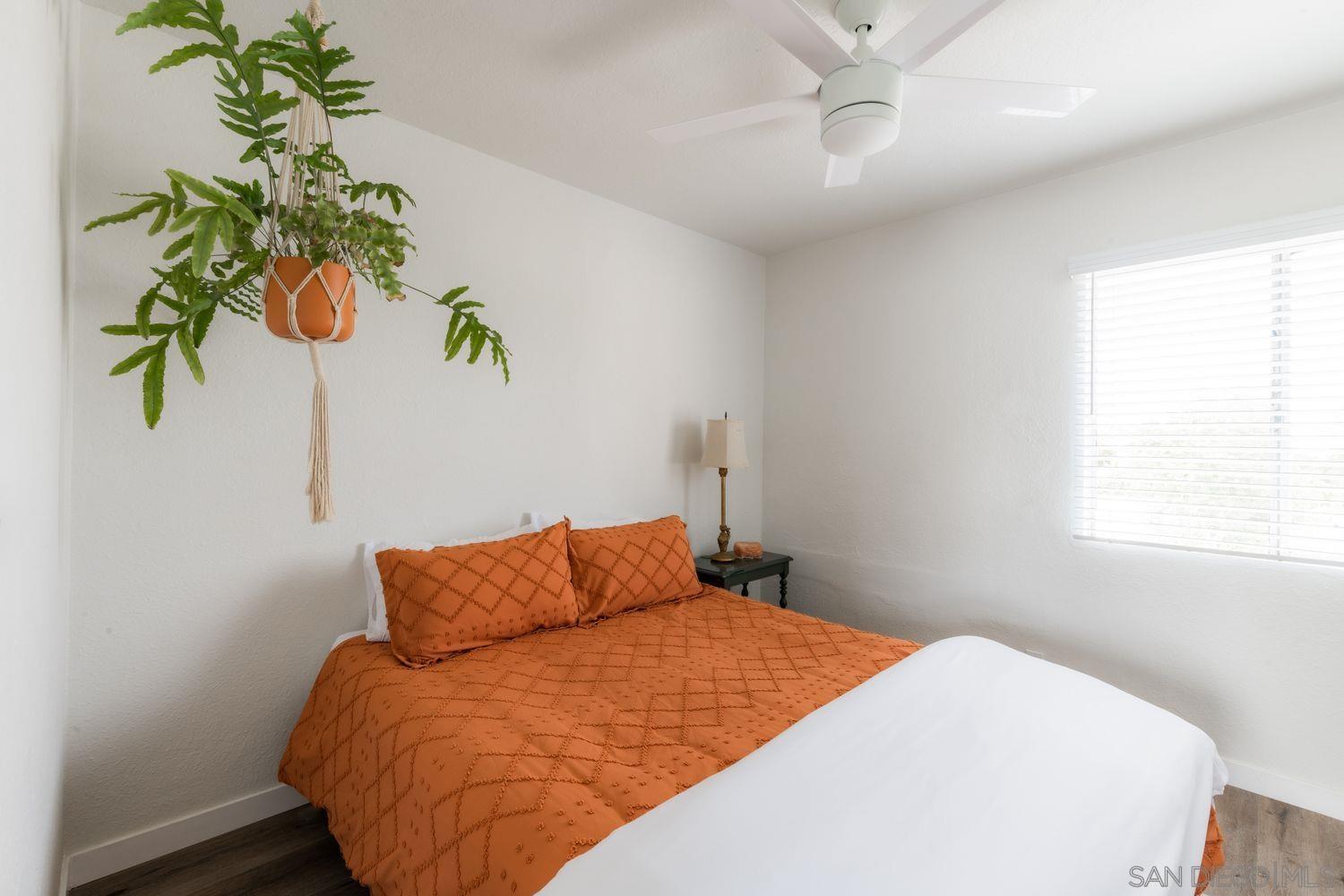 2948 Franklin Avenue San Diego, CA 92113 - Photo 43 of 47 a bedroom with a bed plant and a window