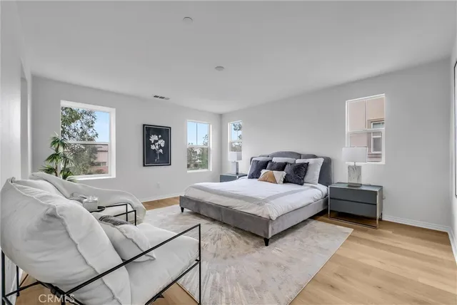 a spacious bedroom with a bed and a painting on the wall