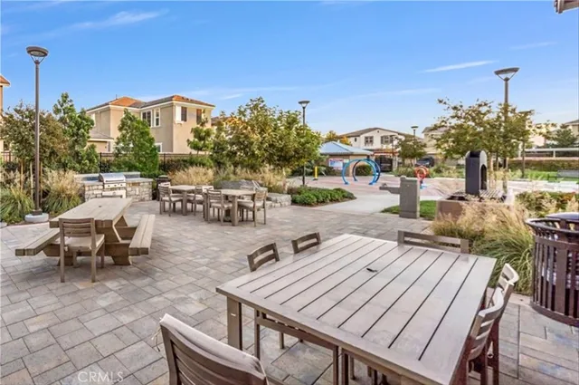 a view of a patio with couches and table and chairs and potted plants