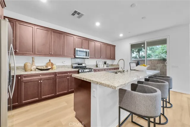a kitchen with kitchen island granite countertop a sink and a stove top oven