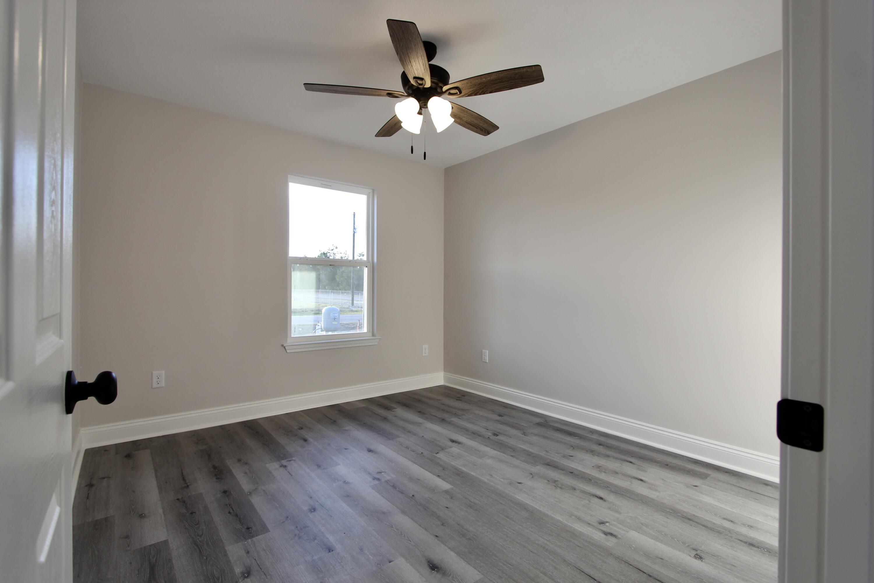 5437 Bayleaf Drive Crestview, FL 32539 - Photo 17 of 35 wooden floor in an empty room with a window