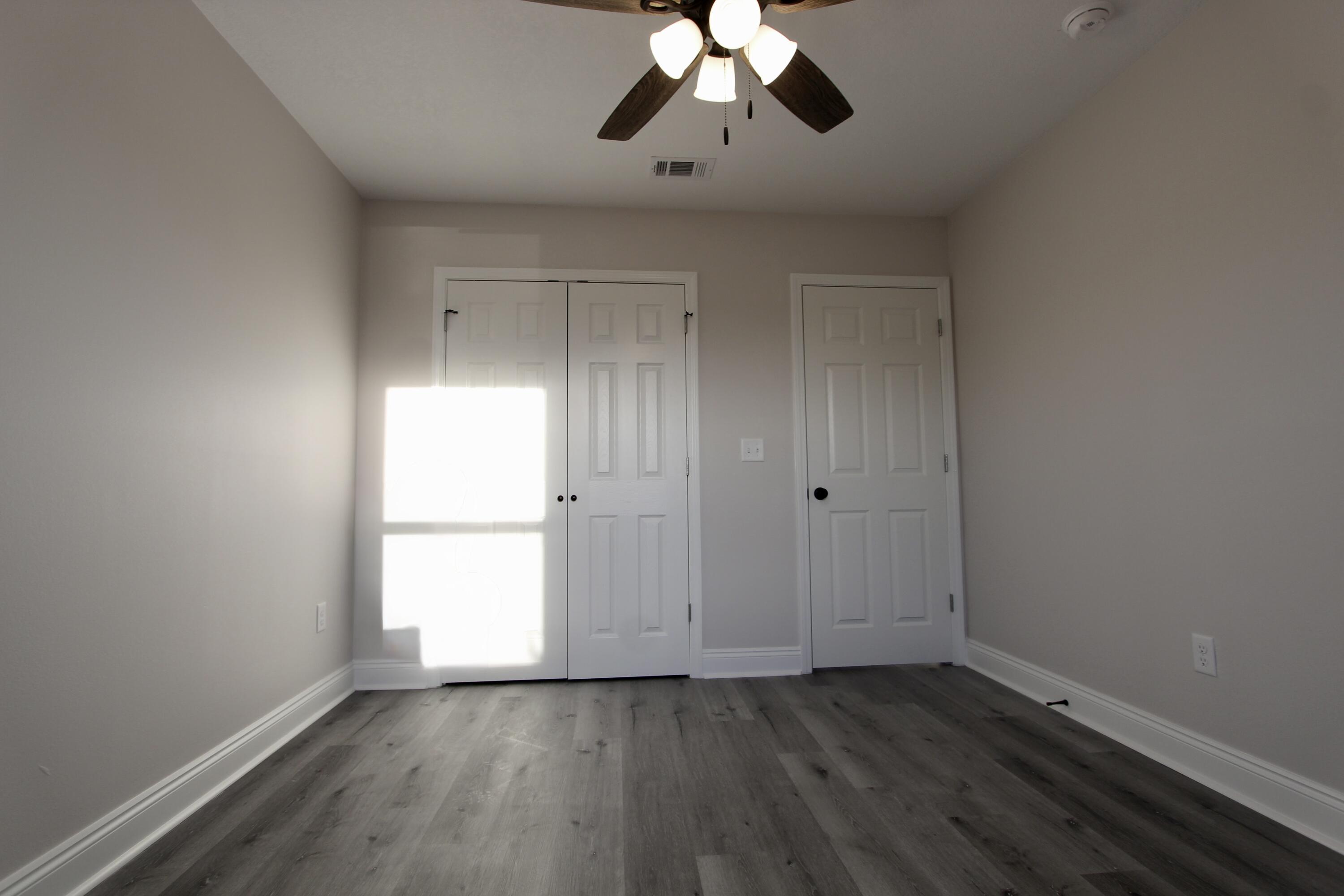 5437 Bayleaf Drive Crestview, FL 32539 - Photo 18 of 35 a view of an empty room with wooden floor and a window