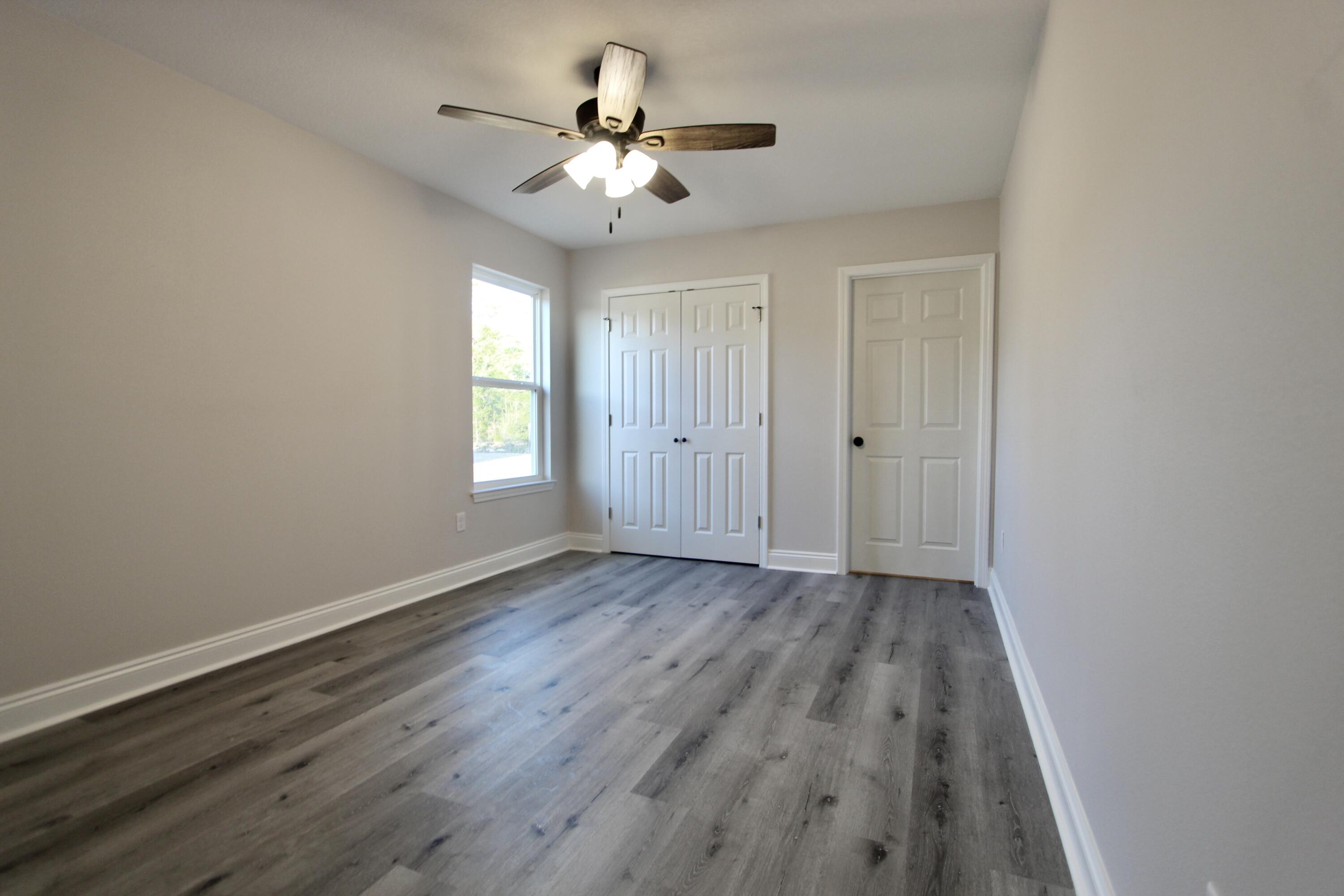 5437 Bayleaf Drive Crestview, FL 32539 - Photo 23 of 35 wooden floor in an empty room with a window