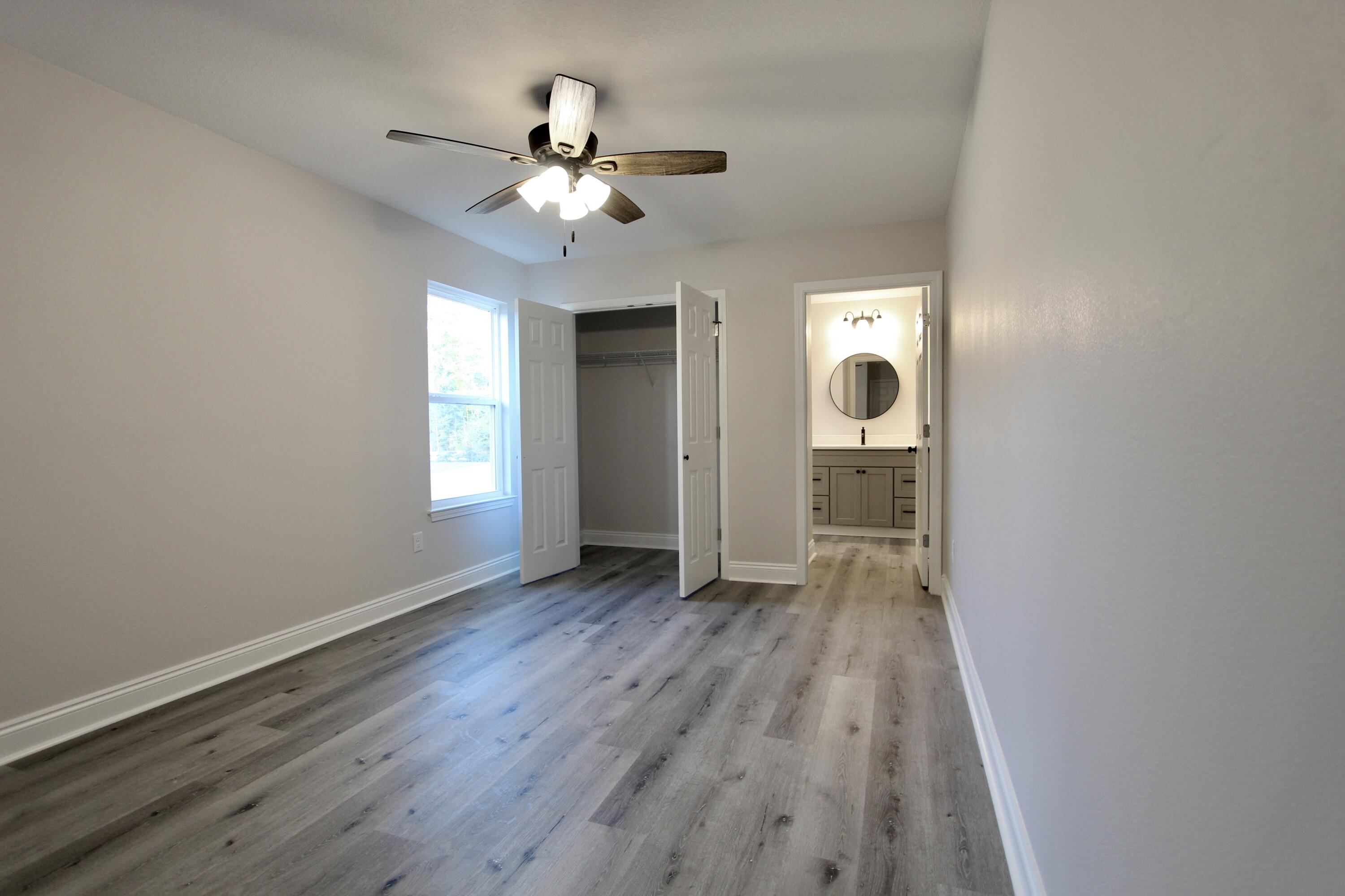 5437 Bayleaf Drive Crestview, FL 32539 - Photo 24 of 35 wooden floor in an empty room with a window