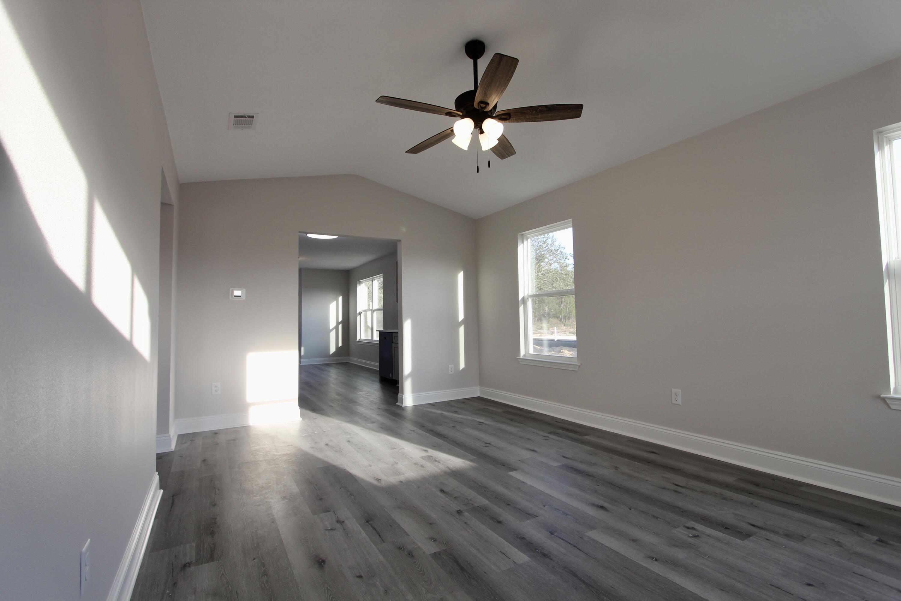 5437 Bayleaf Drive Crestview, FL 32539 - Photo 6 of 35 a view of empty room with wooden floor and fan