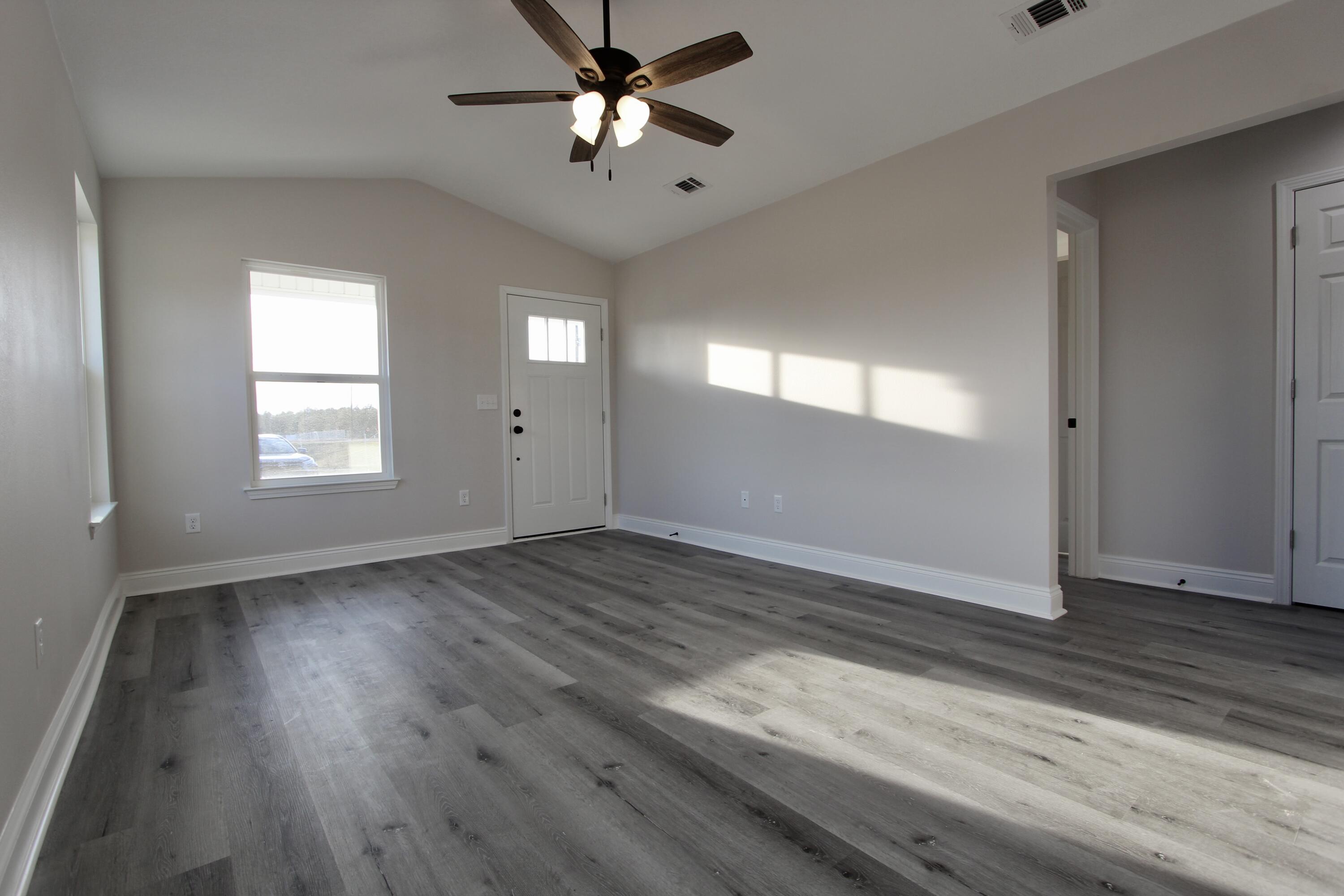 5437 Bayleaf Drive Crestview, FL 32539 - Photo 7 of 35 wooden floor in an empty room with a window