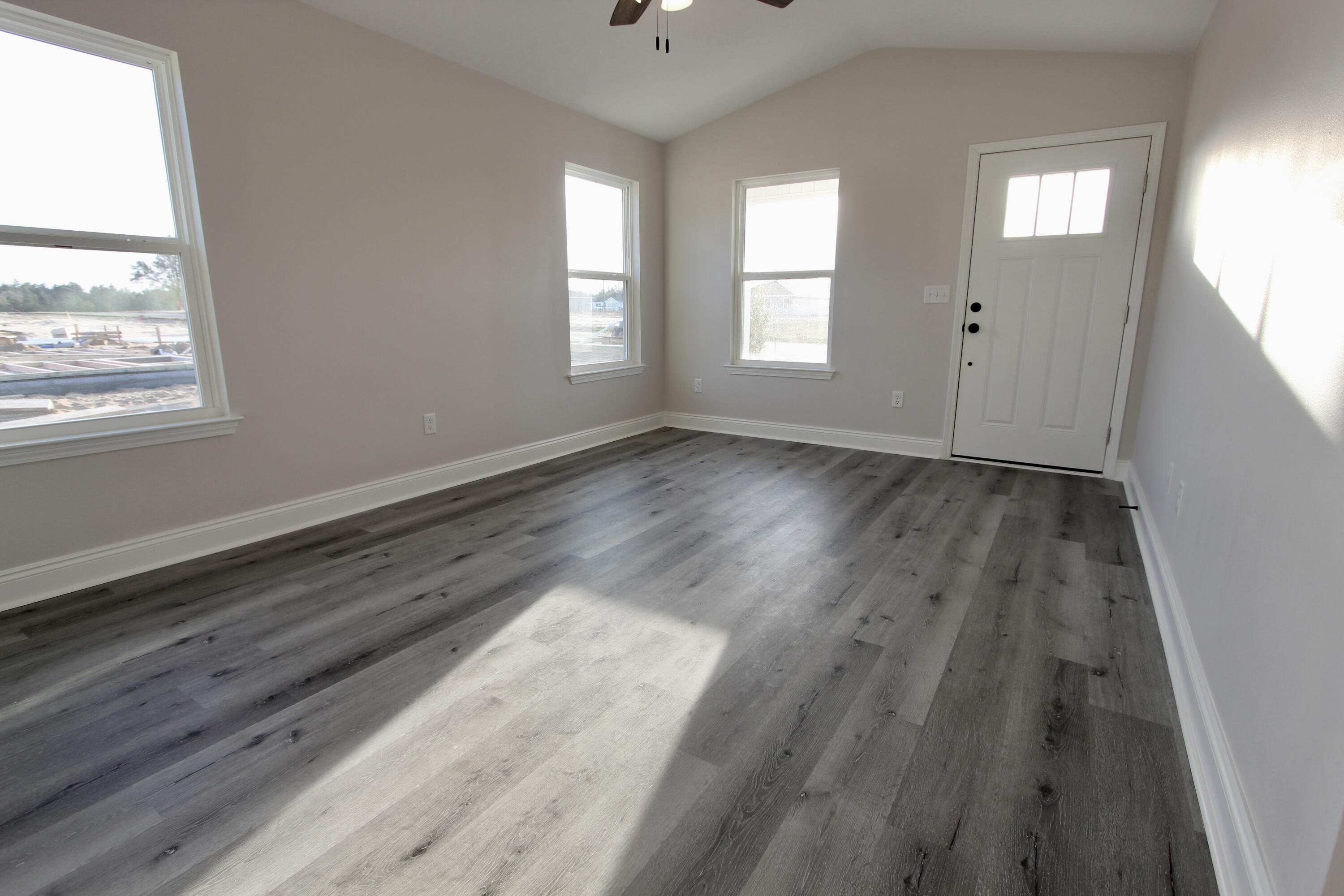 5437 Bayleaf Drive Crestview, FL 32539 - Photo 8 of 35 wooden floor in an empty room with a window