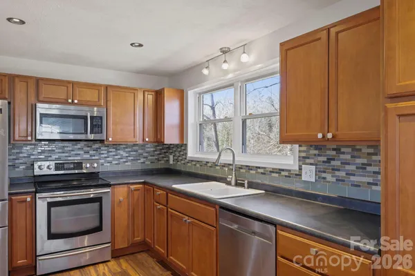 a kitchen with stainless steel appliances wooden cabinets and a stove top oven