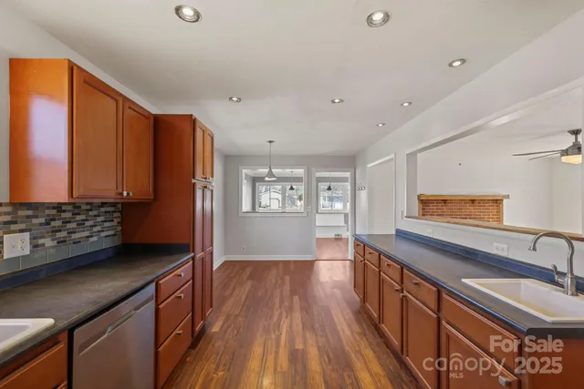 a kitchen with granite countertop a sink cabinets and wooden floor